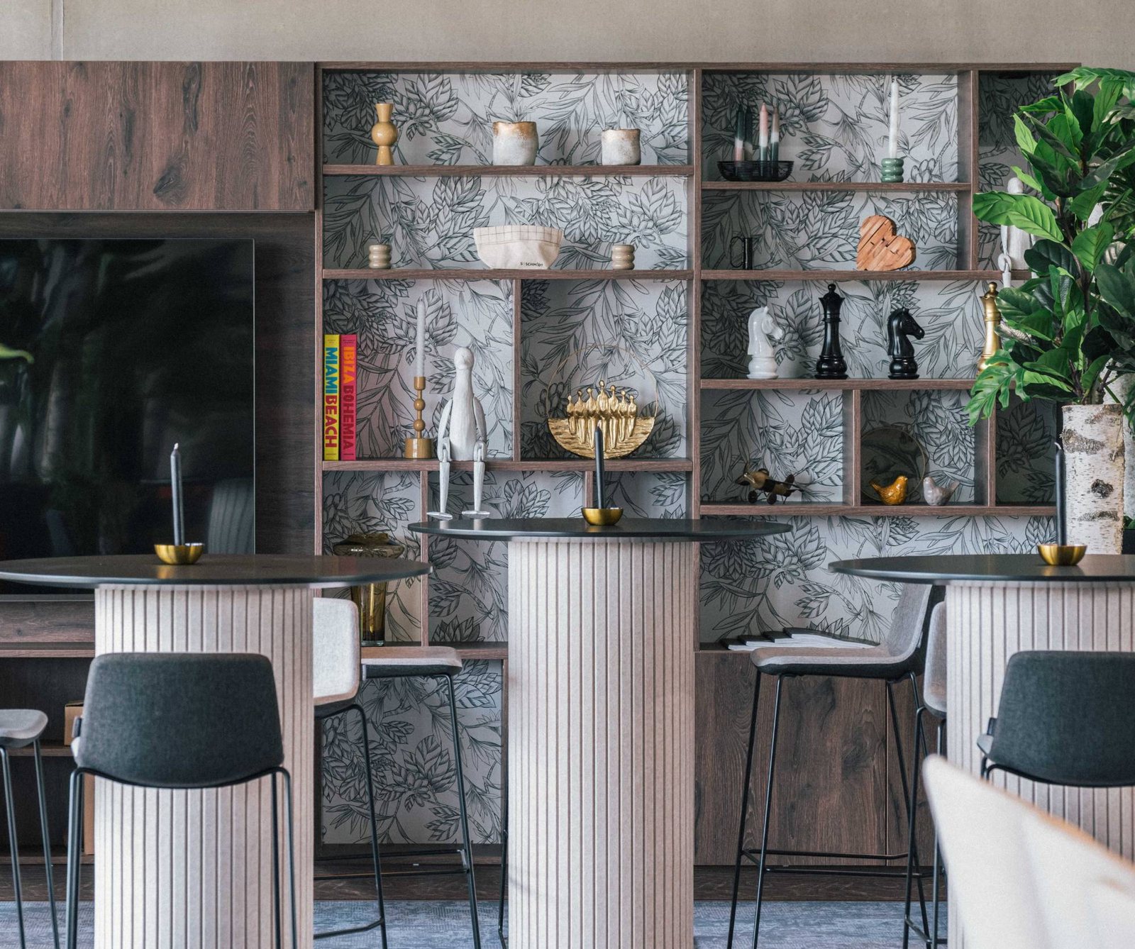 Coin lounge d’un hôtel avec étagère décorative et tables hautes